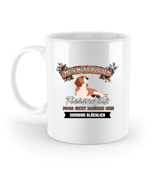 Weiße Keramik-Tasse (330 ml) mit dem Spruch Mein Hund aus dem Tierschutz muss nicht dankbar, sondern glücklich sein. Motiv auf einer Seite, Henkel links.